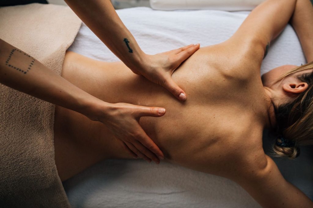 Mujer recibiendo un masaje modelador brasileño en el abdomen en una cabina de estética
