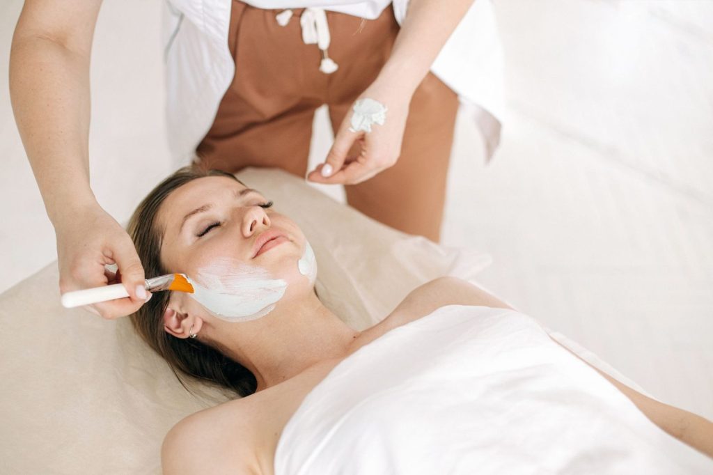 Mujer recibiendo el tratamiento facial Soin Tomate Glow en una cabina de estética